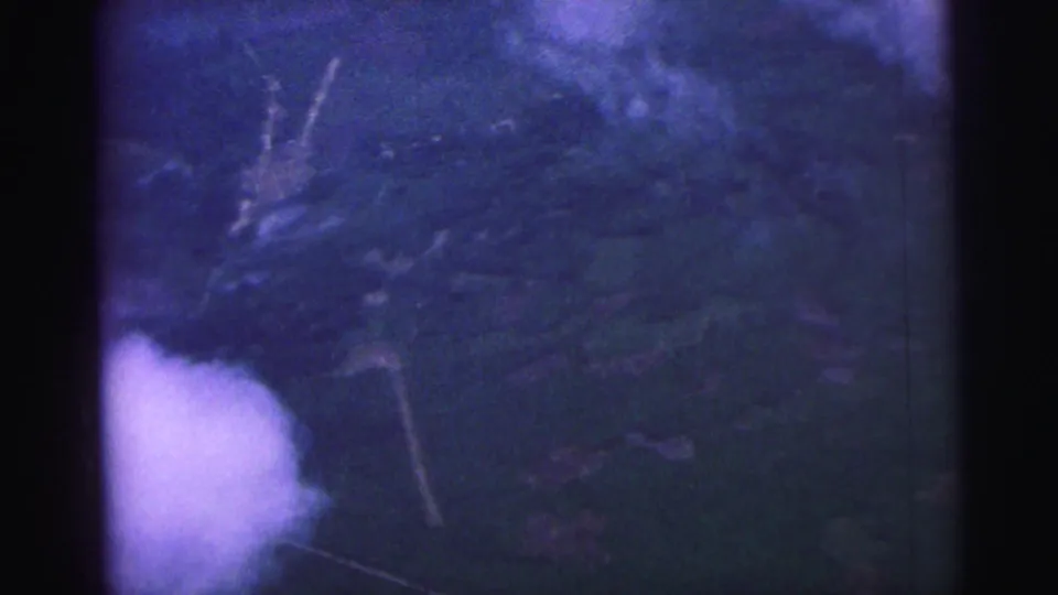 Blurred 1967 Brazil 8mm aerial view looking down at ground and vegetation from inside or near the plane.