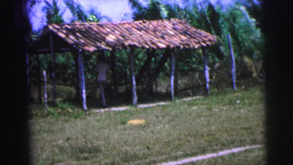 The 1967 Brazil footage shows a rustic open shelter with tiled roof and a traveler partly visible beneath it.