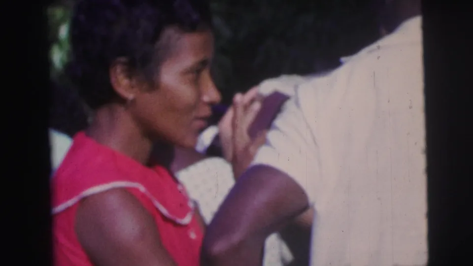 The final frame shows the woman in red beside a white-shirted participant, her hand near their arm in a close, candid ceremony moment.