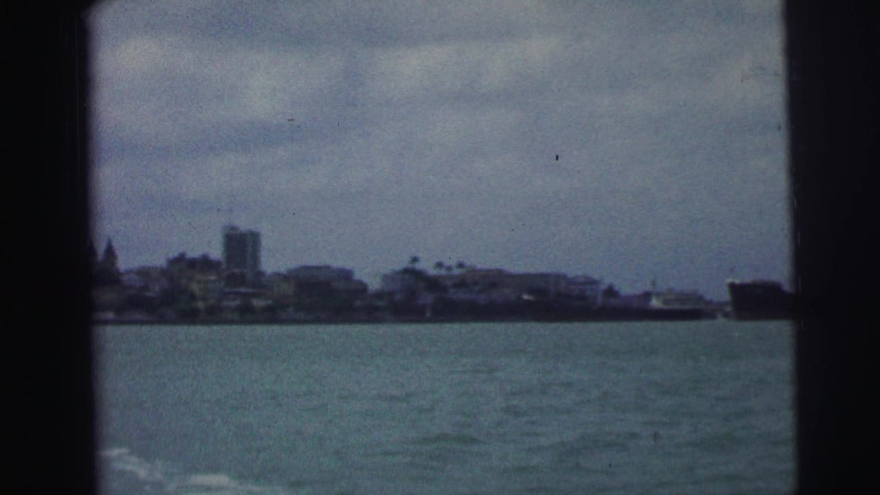 Distant coastal skyline across water with dark 8mm frame borders.