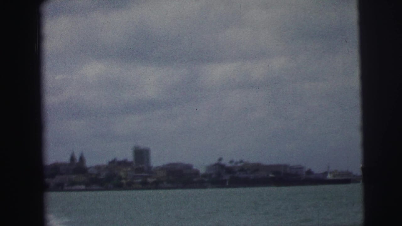 Waterfront skyline across water with film gate edges visible.