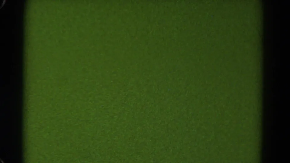 Green 8mm film frame with a dark vertical border and faint grain, likely from film exposure or camera error.