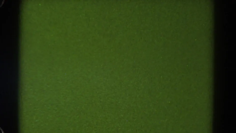 Green 8mm frame with a dark vertical film border, visible grain, and a horizontal frame boundary across the upper area.