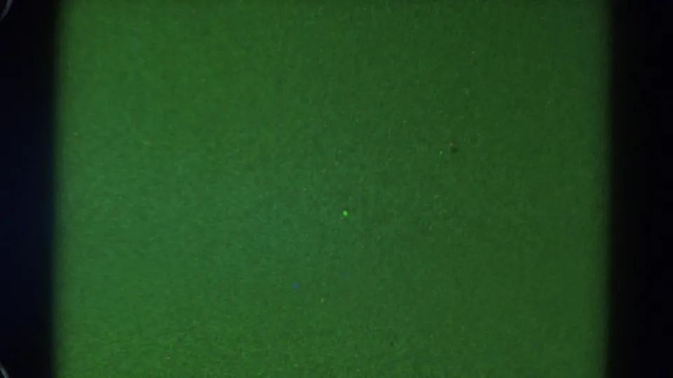 1967 Colorado 8mm frame with a solid green surface, black vertical borders, soft grain, and minor speckling.
