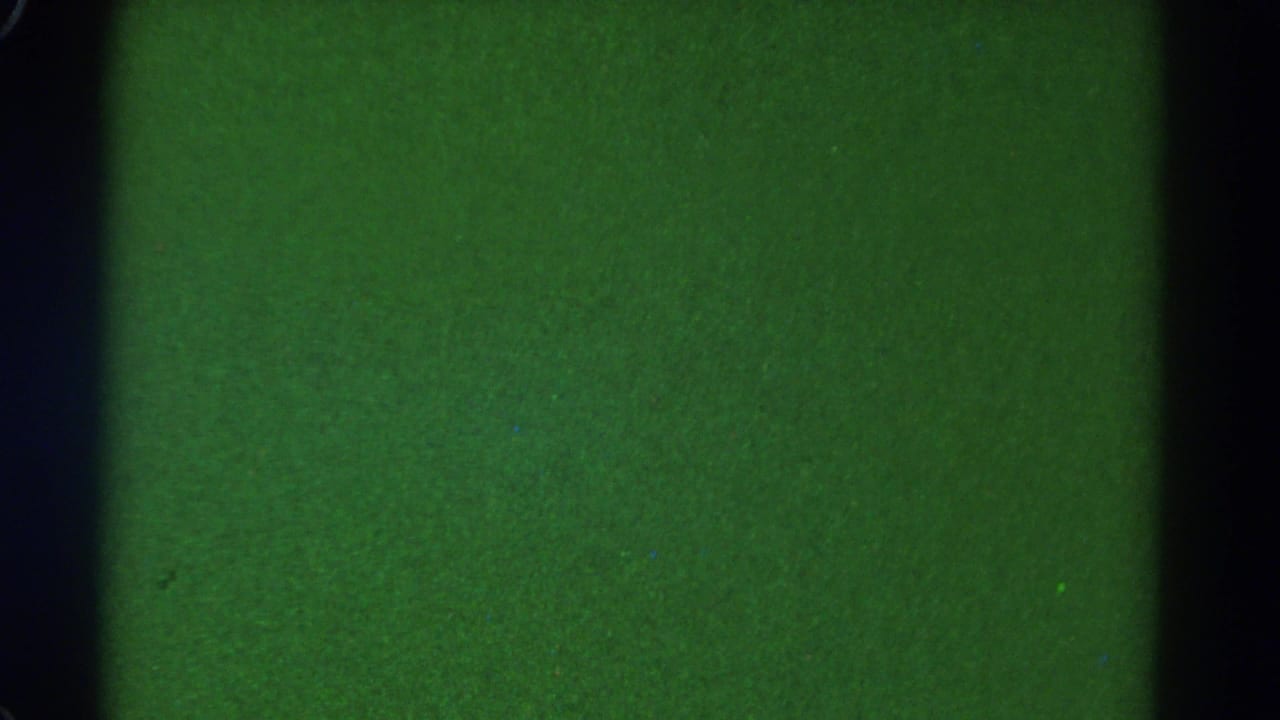 Underexposed 1967 8mm frame from Colorado train footage, with green cast and dark vertical window framing.