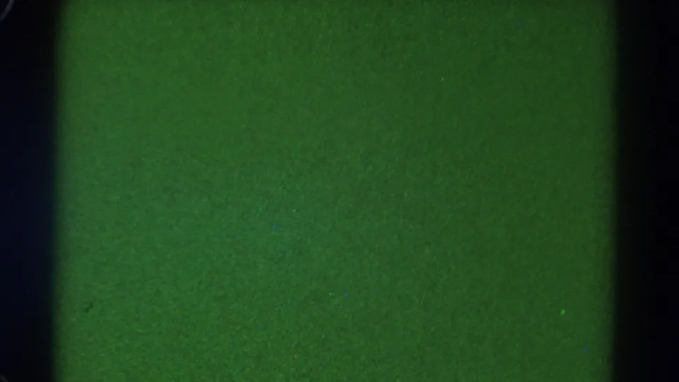 Underexposed 1967 8mm frame from Colorado train footage, with green cast and dark vertical window framing.