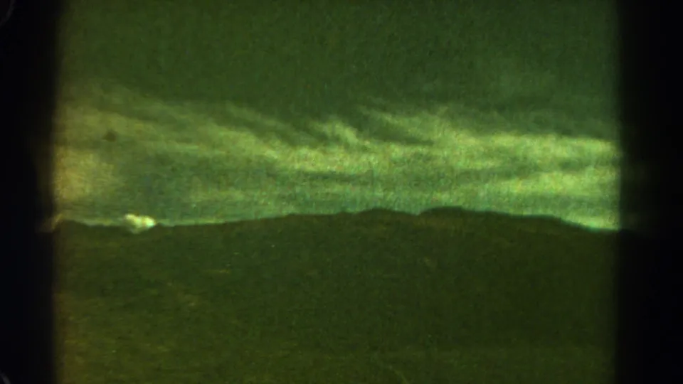 1967 8mm Colorado view of a dark mountain horizon under a cloudy green-tinted sky, divided by visible film or contact-sheet borders.