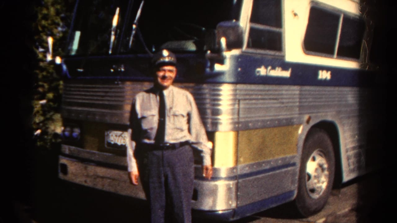 Uniformed male bus driver poses beside a silver and blue coach in Colorado archival 8mm footage from 1967.