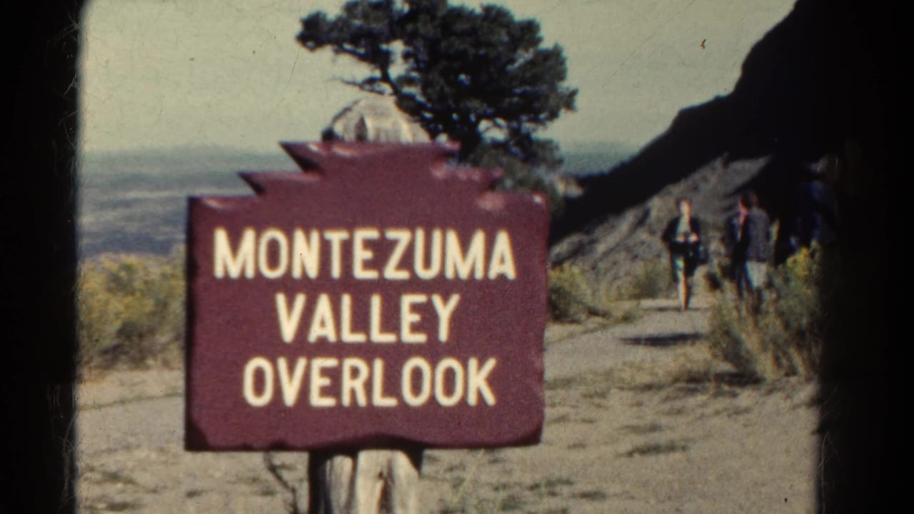 1967 8mm Colorado view of the Montezuma Valley Overlook sign with visitors moving along the path at right.