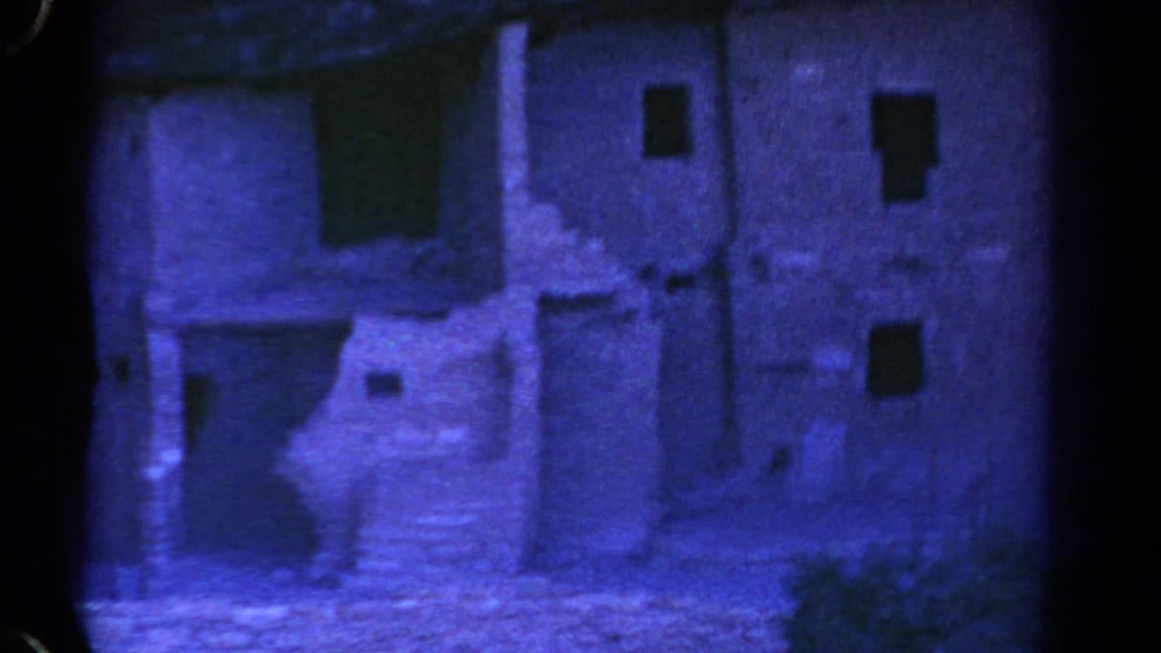 1967 Colorado 8mm frame showing a blue-tinted ancient-looking ruin wall with small rectangular openings and stepped stonework.