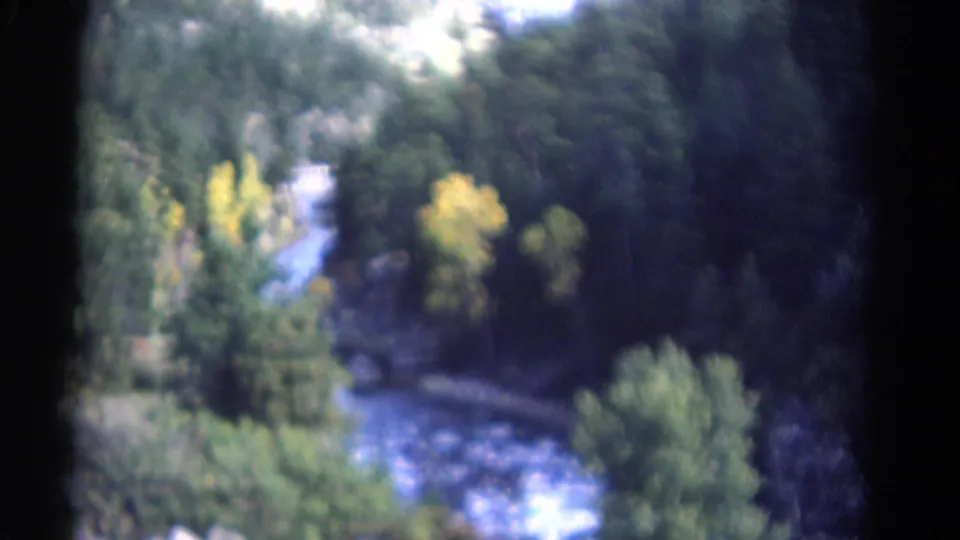 1967 Colorado 8mm frame with soft-focus rapids, dense trees, and rocky canyon edges seen from above.