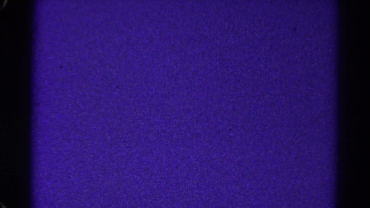 1967 Colorado 8mm frame showing a violet textured film field, dark edge borders, grain, and a black vertical divider.