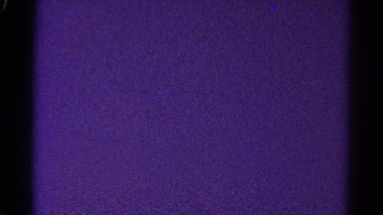1967 Colorado 8mm frame with a purple textured field, black center divider, dark side edge, and visible grain.