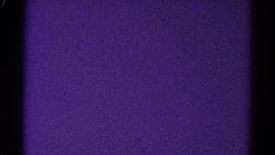 1967 Colorado 8mm frame with a purple textured field, black center divider, dark side edge, and visible grain.