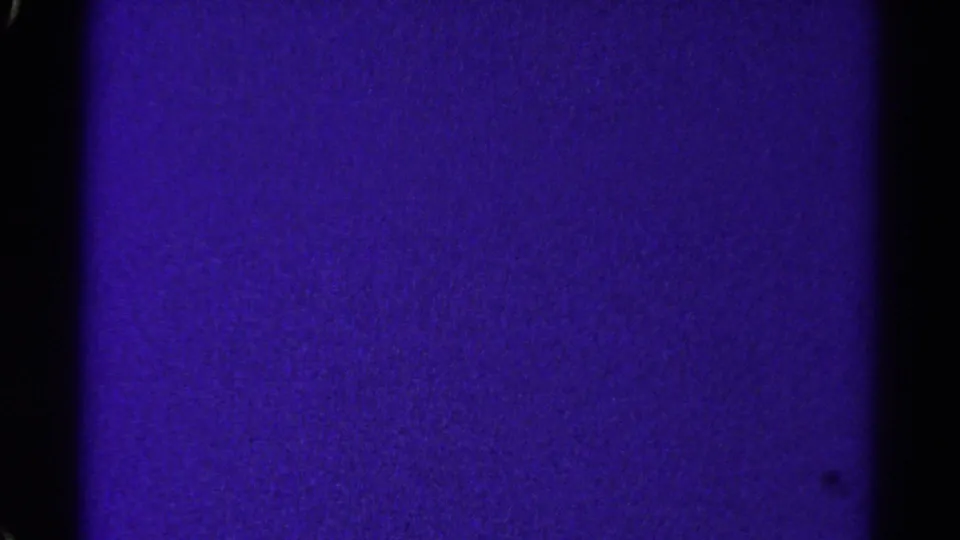 1967 Colorado 8mm frame showing a darker violet film surface with grain, black borders, and slight exposure variation.