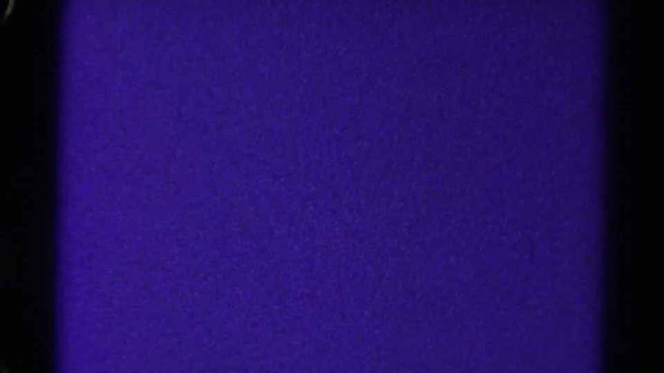 1967 Colorado 8mm frame showing a purple textured field that appears slightly lighter in areas, with grain and black frame edges.