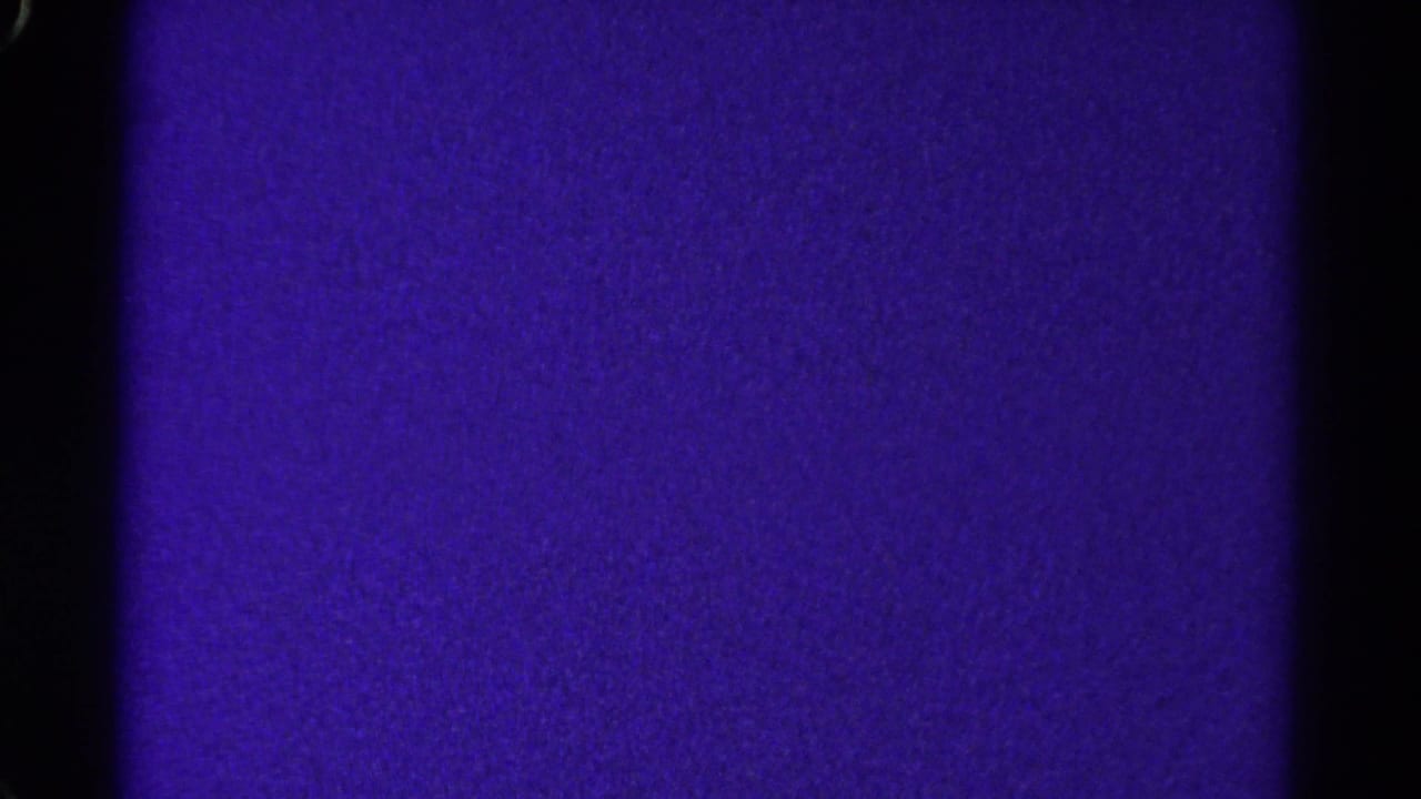 A 1967 Colorado 8mm frame showing a purple exposed field, black gate borders, and fine film grain with no visible subjects.