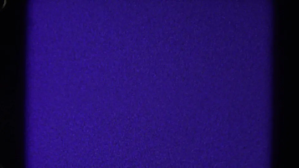 A 1967 Colorado 8mm frame showing a purple exposed field, black gate borders, and fine film grain with no visible subjects.