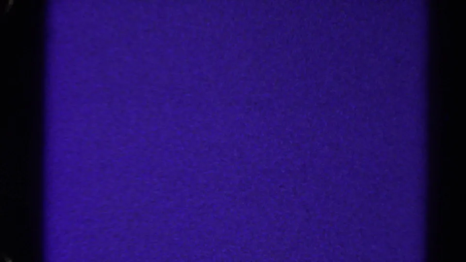 A grainy purple 8mm frame from the 1967 Colorado source, showing dark side borders, slight tonal shifts, and no identifiable people or objects.