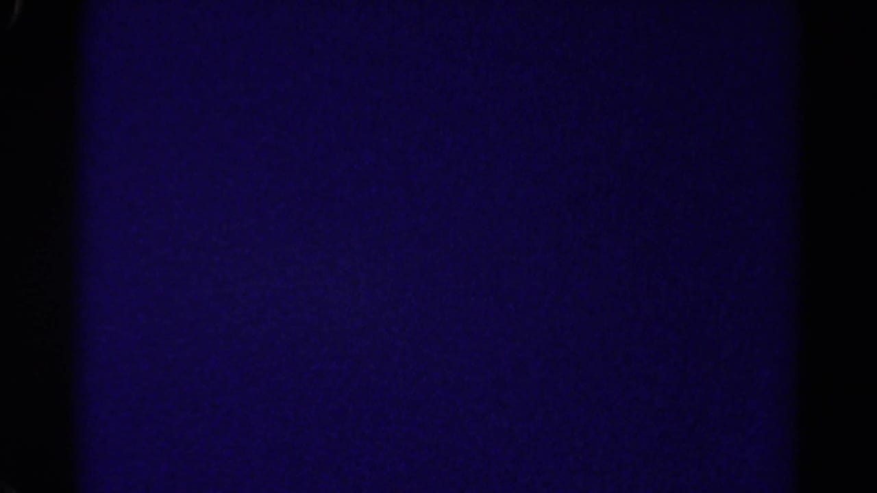 Mostly dark purple transition frame with film edge shadows.