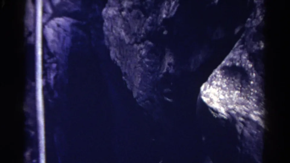 1967 Colorado 8mm frame with blue-toned cave rock, a bright wet-looking formation, and heavy shadow across the interior.