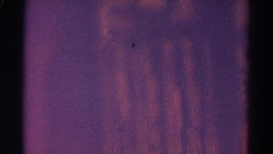 Purple-red abstract 8mm frame with heavy grain, dark edges, and soft exposure shift during the transition.