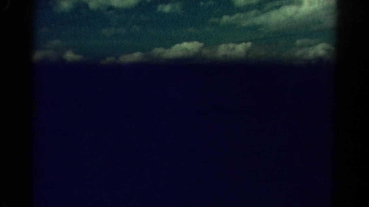 Mostly dark blue frame with a narrow cloudy sky band at the top.