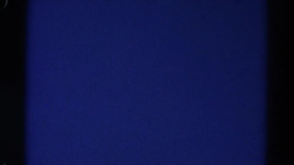 The clip ends on a dark blue 8mm frame with visible grain, black borders, and no identifiable subject.