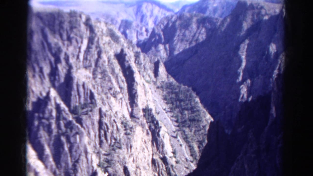 Rocky mountain canyon seen through a dark-edged film frame.