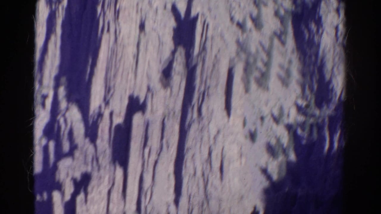 Close view of a rugged cliff face with deep vertical shadows.