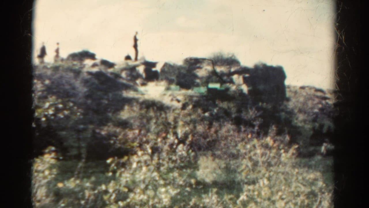 Two or more distant people appear on a rocky Colorado hillside in this 1967 8mm travel shot.