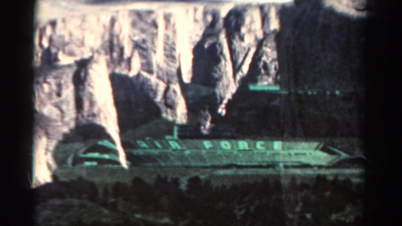 Stadium lettering and rocky cliffs seen through a dark film frame.