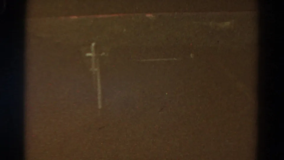 A utility or telegraph pole appears faintly in a dark, grainy 1967 Colorado 8mm frame shot from a moving vehicle.