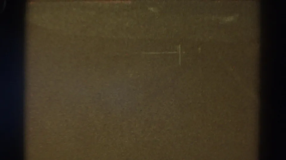 Dark underexposed 1967 Colorado 8mm frame with brown-black tone, visible film edge, dust, grain, and faint scratch marks.