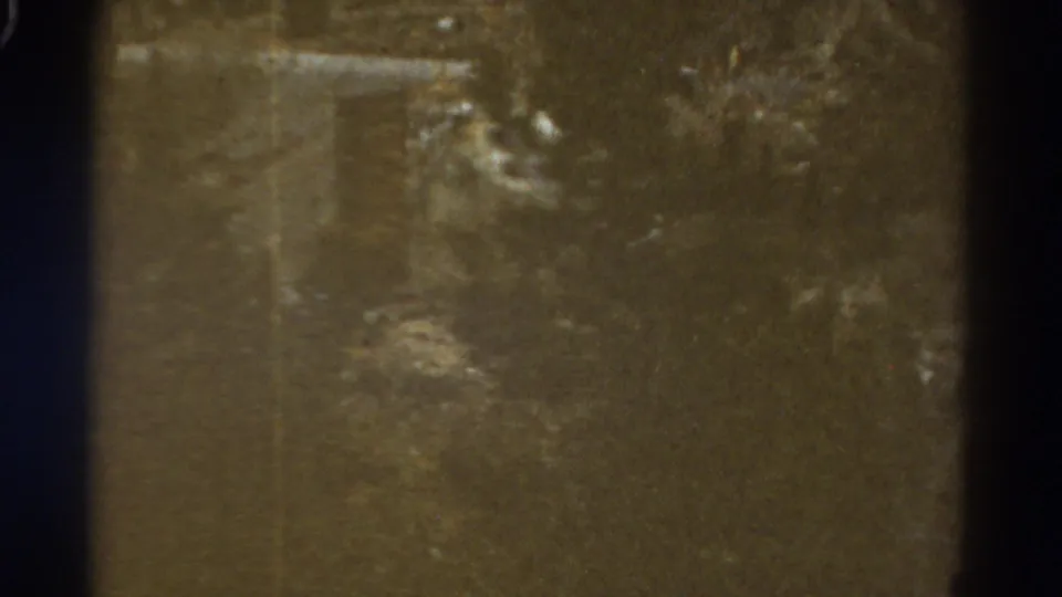 A soft 1967 Colorado frame appears to show a road cut or embankment along a steep hillside, with dark gate edges visible.