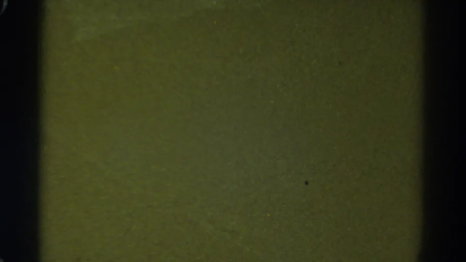 1967 Colorado 8mm frame with soft green texture, dark gate edges, grain, dust, and no identifiable subject.