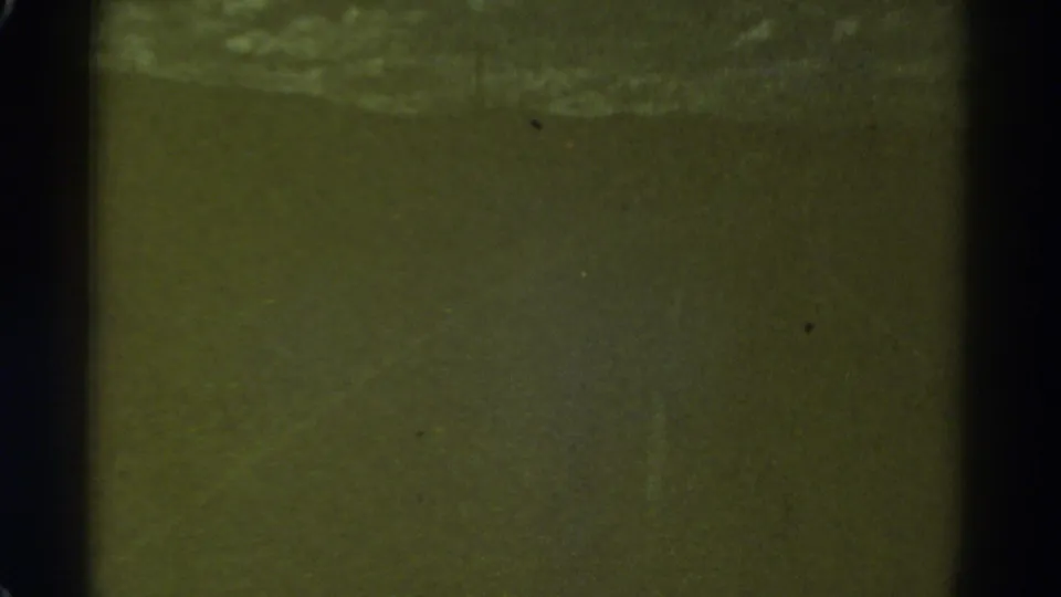 1967 Colorado 8mm frame showing a dark, low-contrast roadway area with grain, dust and muted color.