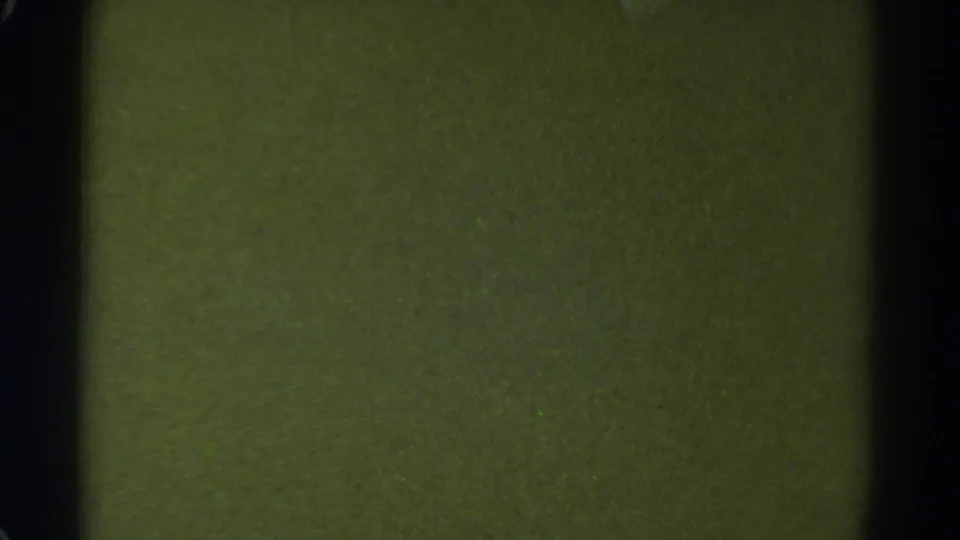 1967 Colorado 8mm frame with a mostly blank green-yellow surface, dark side borders, faint scratches, and film grain.