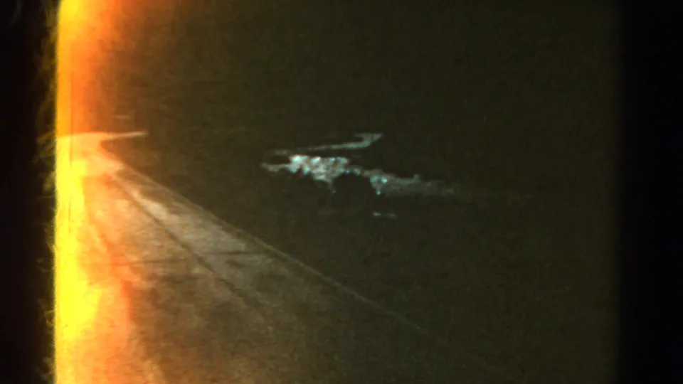 1967 Colorado 8mm frame showing intense orange-yellow light beside a dark road surface, with a blue-white streak likely from reflection or flare.
