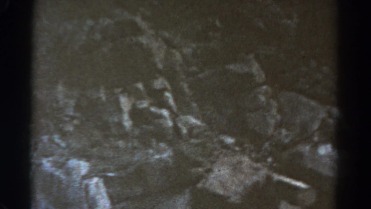 1967 8mm Colorado travel footage begins with a dim, grainy textured view framed by dark film edges.