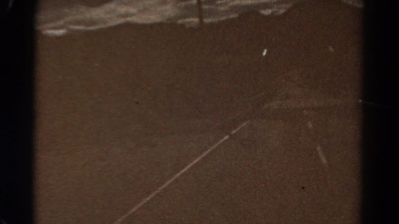 1967 Colorado 8mm frame showing an empty rural road surface, distant hills, cloudy sky and visible film gate edges.