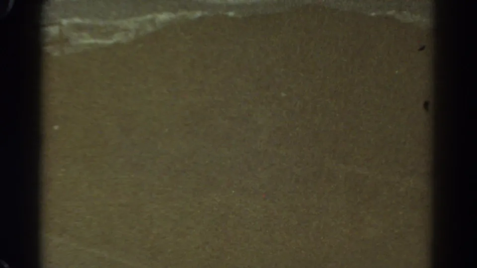 1967 Colorado 8mm frame showing a muted brown ground or landscape surface with faint pale streaking and visible film borders.