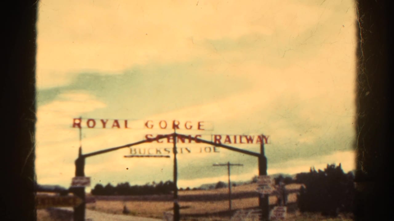 Royal Gorge Scenic Railway sign centered above a rural roadside entrance.