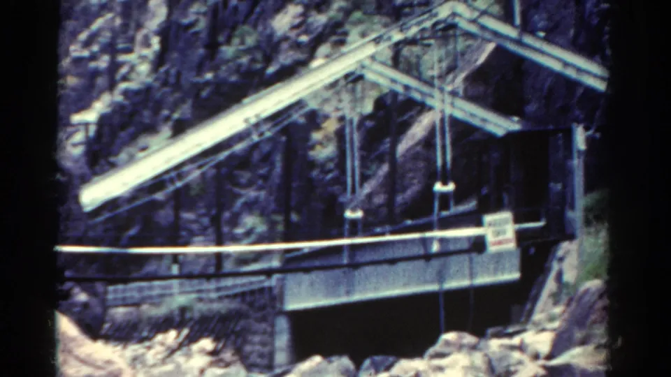1967 Colorado view of a water-control structure built into a steep canyon above a rocky river channel.