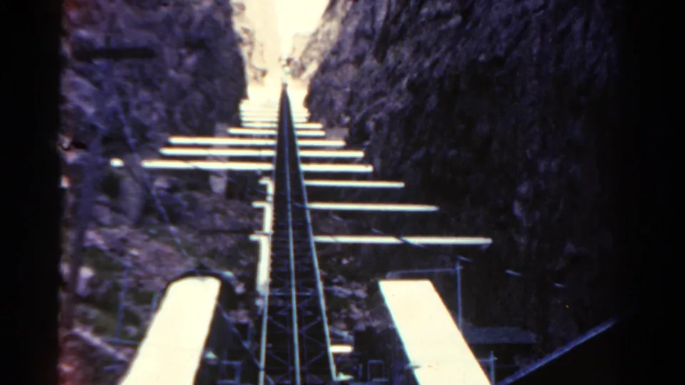 1967 Colorado 8mm frame showing a first-person roller coaster ascent through a narrow canyon-like passage.