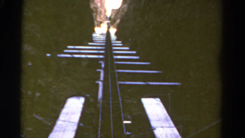1967 Colorado 8mm frame showing a steep narrow railway track ascending toward a bright canyon exit.