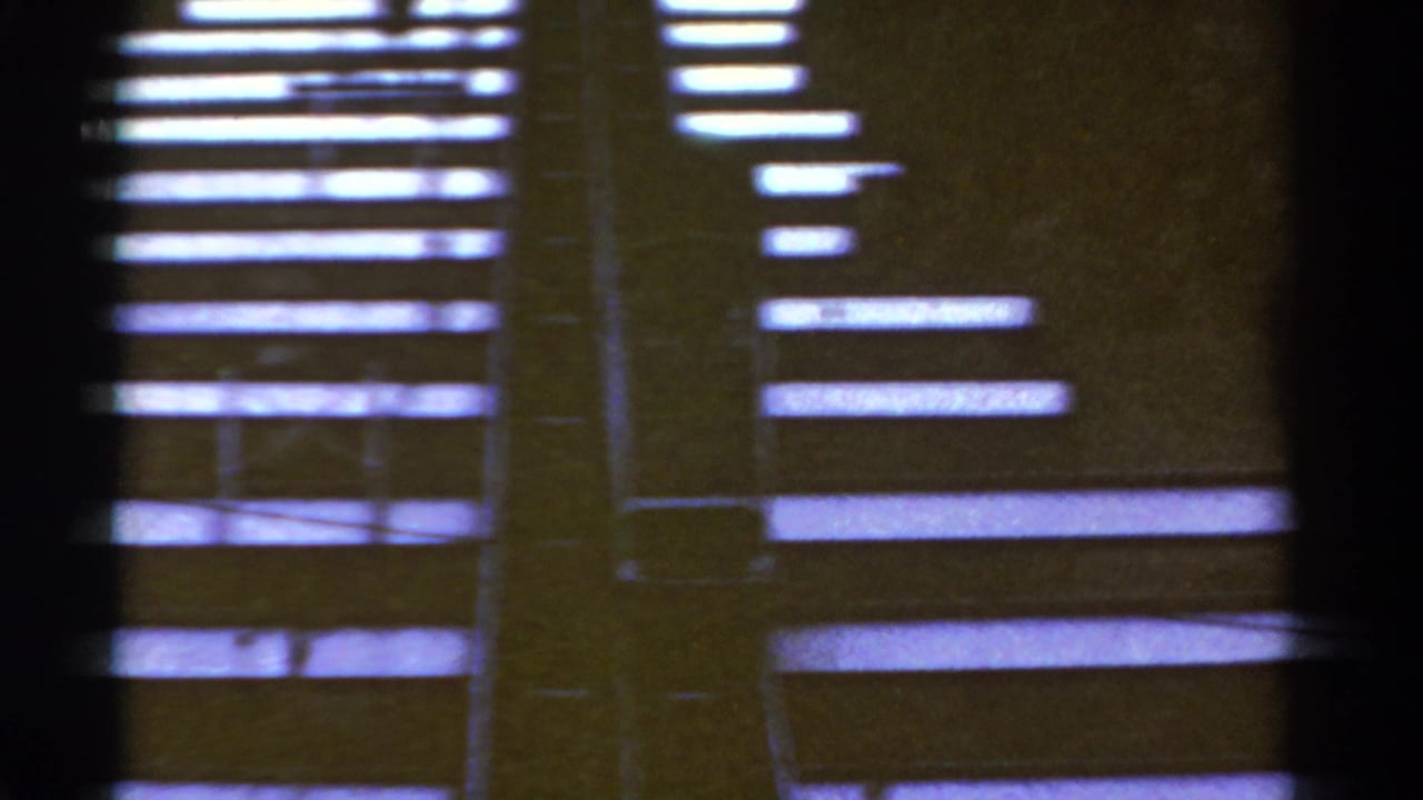1967 Colorado 8mm frame showing an abstracted view of wooden stair shapes, dark film borders, and uneven exposure.