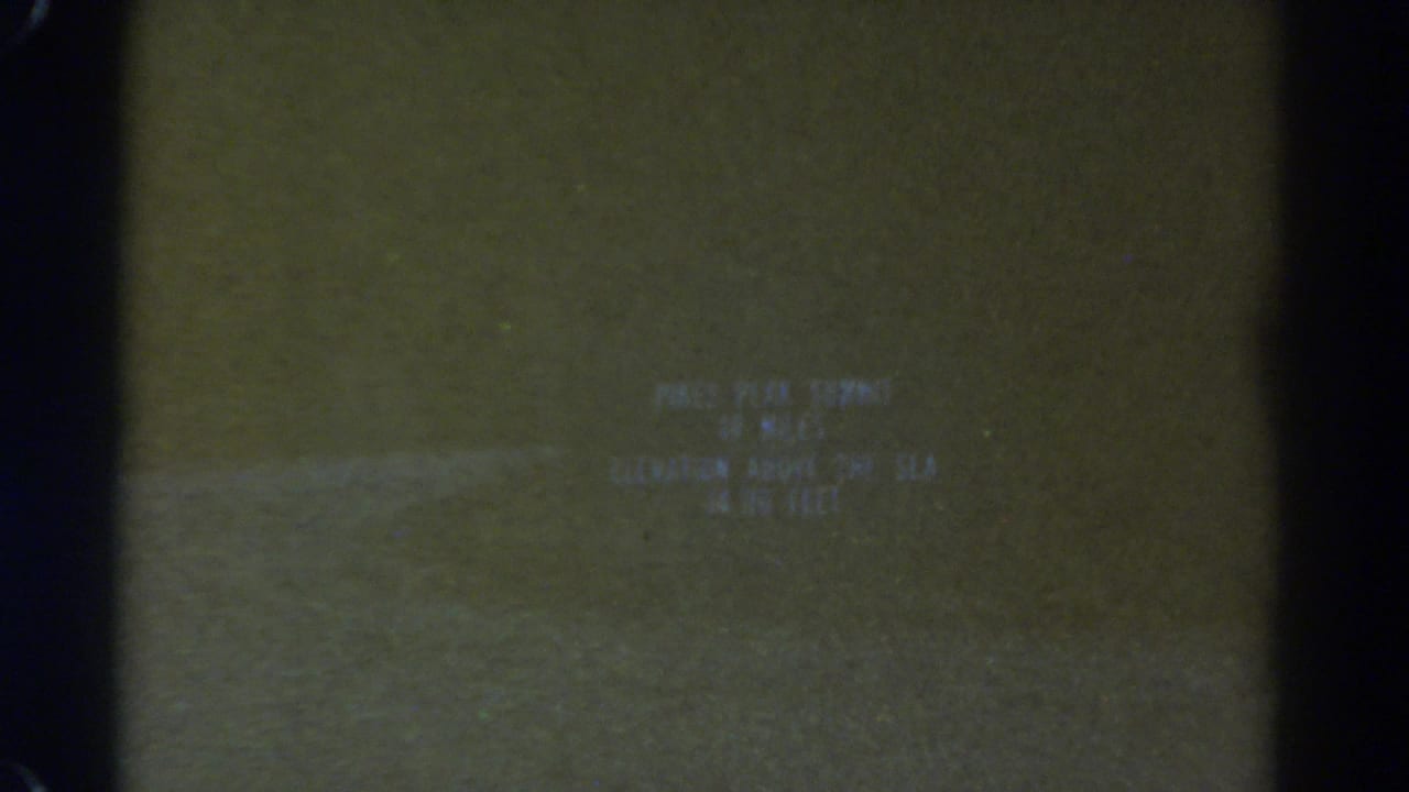 Soft title card text on dark green-brown film with black frame edges.