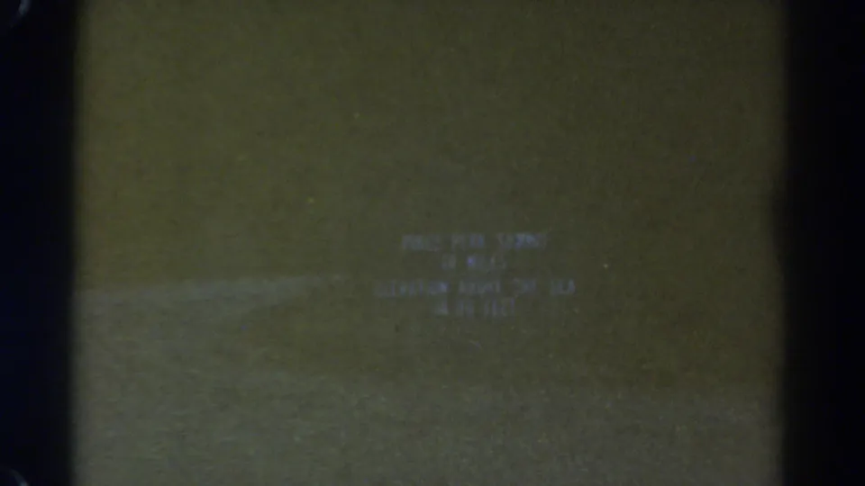 1967 Colorado 8mm frame showing a soft Pikes Peak summit title card with dark film borders and muted exposure.
