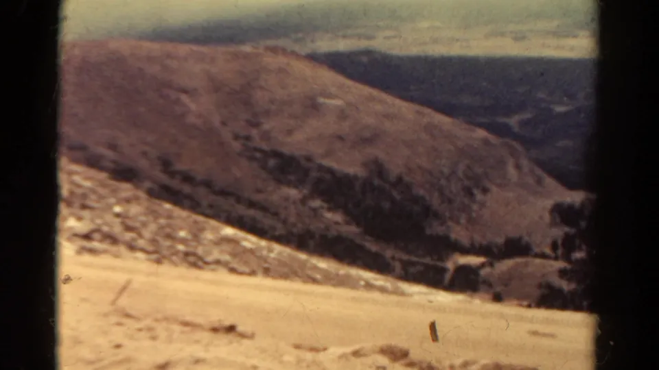 Colorado mountain panorama from 1967 shows a pale rocky hillside, darker valley floor, and distant ridgelines.